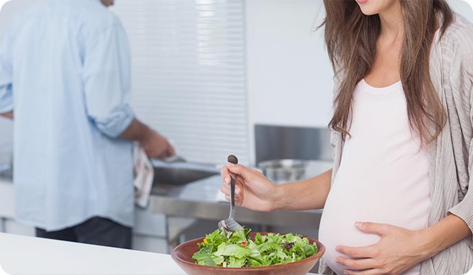 Pregnant woman eating a salad